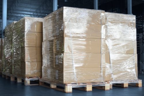 Stacked of Packaging Boxes Wrapped Plastic Film on Pallets in Storage Warehouse. Supply Chain. Storehouse Commerce Shipment. Shipping Warehouse Logistics.